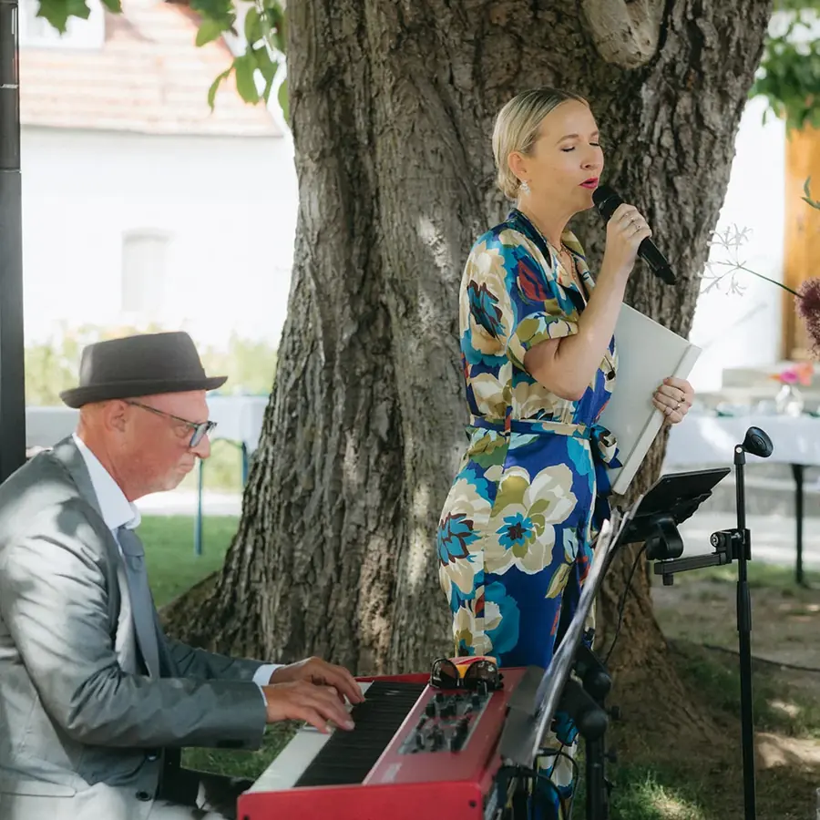 Ola singt unter einem Baum, begleitet am Keyboard, bei einer freien Trauung