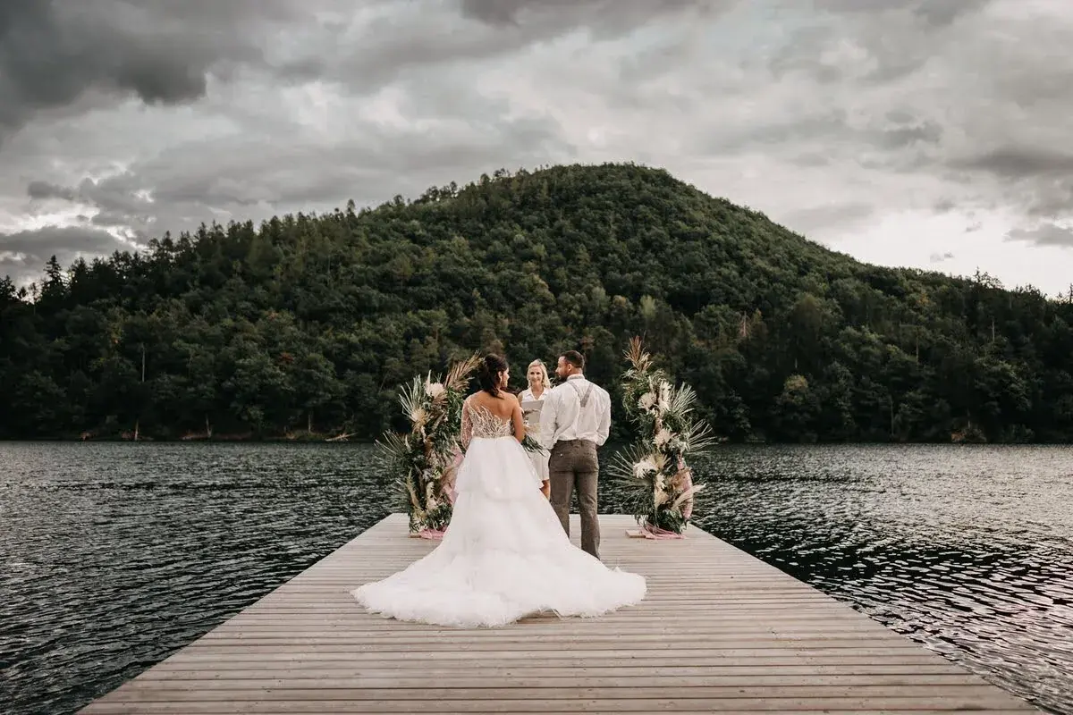 Braut auf dem Steg zur freien Trauung am See in Bayern