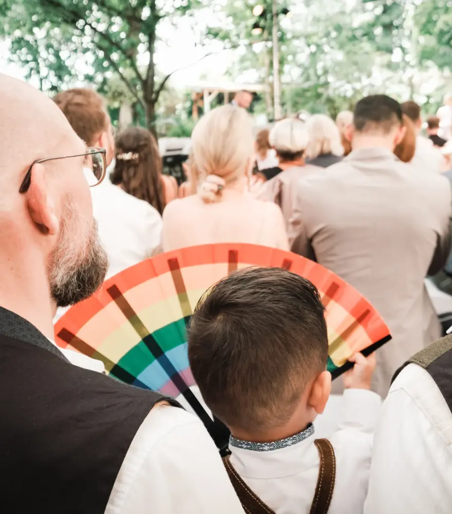 Kind mit Regenbogen-Fächer bei einer gleichgeschlechtlichen freien Trauung